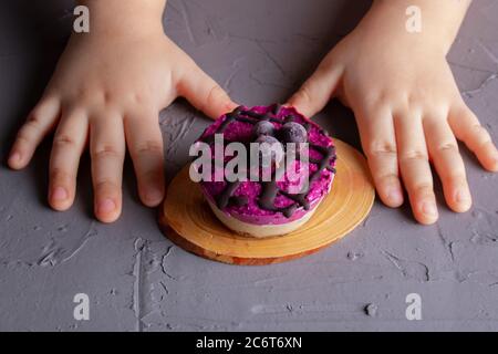 Les enfants se font les mains avec un gâteau au cassis. Gros plan, sans gluten. Dessert de l'école Banque D'Images