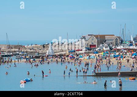 Lyme Regis, Dorset, Royaume-Uni. 12 juillet 2020. Météo au Royaume-Uni: La foule des amateurs de plage se rassemblent dans la station balnéaire pittoresque de Lyme Regis pour profiter du soleil brûlant. Ce week-end, les familles, les visiteurs et les amateurs de soleil ont fait le plein de la plage pour profiter du meilleur du temps ensoleillé tandis que les touristes rentraient un séjour agréable dans la station balnéaire populaire. Crédit : Celia McMahon/Alay Live News Banque D'Images