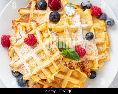 Gaufres belges avec framboises, bleuets, caillé et thé, vue du dessus. Banque D'Images