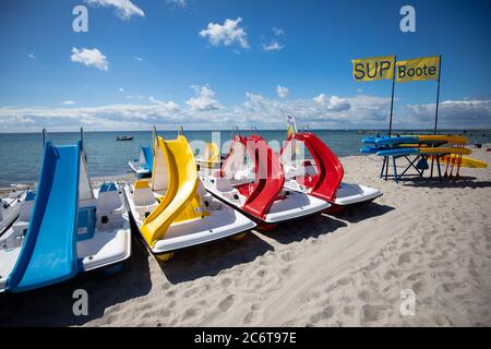 12 juillet 2020, Schleswig-Holstein, Burg/Fehmarn: Des bateaux à pédales avec toboggans et panneaux SUP sont disponibles à la location à une station de location sur la plage sud près de Burg sur Fehmarn. Dans les jours à venir, le soleil et les nuages alternent dans le nord. Photo: Christian Charisius/dpa Banque D'Images