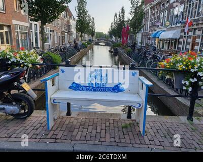 Banc blanc bleu sur le canal Turfmarkt dans la vieille ville de Gouda, ville de fromage aux pays-Bas Banque D'Images