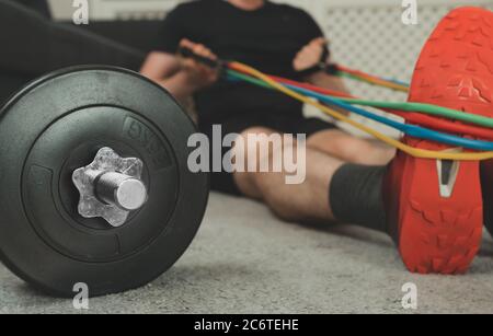 Homme faisant des exercices avec des bandes de résistance à la maison. Concept de fitness à domicile. Banque D'Images
