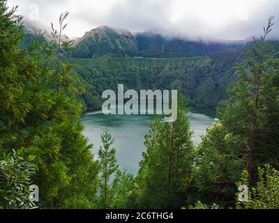 Belle vue sur le lac Lagoa de Santiago avec des arbres verts et des collines envolées par le brouillard de Miradouro do Cerrado das Freiras, Açores, Sao Miguel Banque D'Images