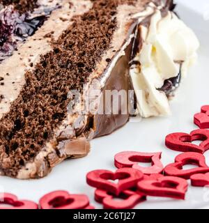 Gâteau au chocolat glaçage dessert rouge coeur assiette mousse de bois crème Banque D'Images