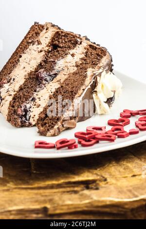 Gâteau au chocolat glaçage dessert rouge coeur assiette mousse de bois crème Banque D'Images