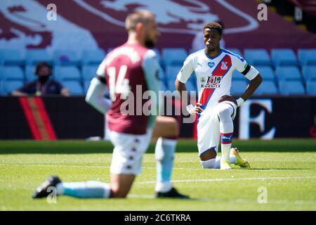 Wilfried Zaha du Crystal Palace se met au genou en l'honneur du mouvement Black Lives Matter lors du match de la Premier League à Villa Park, Birmingham. Banque D'Images