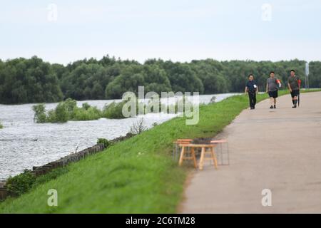 (200712) -- YUEYANG, 12 juillet 2020 (Xinhua) -- des membres du personnel patrouillent dans une digue le long du lac Dongting, dans la ville de Yueyang, dans la province du Hunan, au centre de la Chine, le 12 juillet 2020. L'eau de l'une des stations hydrologiques du deuxième plus grand lac d'eau douce de Chine a dépassé le niveau garanti en raison des précipitations continues et des apports en amont. Vers 3 h, dimanche, l'eau de la station hydrologique Chenglingji du lac Dongting, dans la province centrale de Hunan, a atteint 34.56 mètres, 0.01 mètres de plus que le niveau garanti, et 2.06 mètres de plus que le niveau d'avertissement, selon l'autho local Banque D'Images