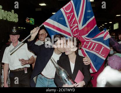 Le champion du monde de Formule un Damon Hill avec sa femme Georgie arrivant à l'aéroport de Londres Heathrow après avoir remporté le championnat au Japon en 1996. Banque D'Images