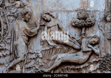 Dieu crée Ève à partir d’une côte d’Adam endormie, dans les années 1300, bas-relief en marbre de la Bible hébraïque / ancien Testament sur le front ouest de la cathédrale à Orvieto, Ombrie, Italie, le Duomo di Santa Maria Assunta. Cette scène sculptée est attribuée à Lorenzo Maitani (v. 1275 - 1330), qui a conçu la façade gothique tardif de la cathédrale. On pense que Maitani a eu une contribution directe en tant que sculpteur sur deux panneaux couvrant deux des quatre pilastres inférieurs de la façade : un panneau Maitani représente des scènes de la Bible hébraïque / ancien Testament, y compris la scène dans cette image. Banque D'Images