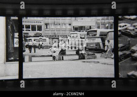 Fine 70s vintage contact Print noir et blanc photographie de personnes se rendant sur leur journée et courir des errands dans la place publique. Banque D'Images