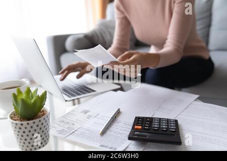 Gros plan de la femme payer des taxes sur ordinateur portable Banque D'Images