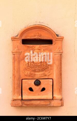 Boîte aux lettres en céramique vintage décorée de branches de relief et de rayures avec texte « posta » et hayon avec serrure. Certaldo. Toscane. Italie. Banque D'Images