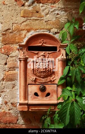 Boîte aux lettres en céramique vintage décorée de branches de relief et de rayures avec texte « posta » et hayon avec serrure. Certaldo. Toscane. Italie. Banque D'Images