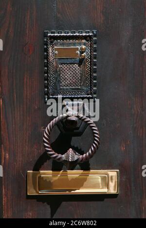 Sonnette de porte en fer d'époque avec porte-sonnette et boîte aux lettres en bronze. Volterra. Italie. Banque D'Images