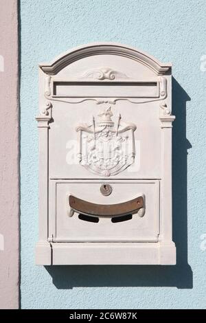 Boîte aux lettres en métal blanc vintage décorée avec des armoiries de secours et une trappe avec serrure. Marina di Pisa. Toscane. Italie. Banque D'Images