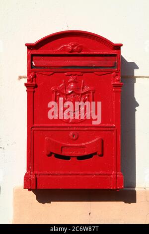 Boîte aux lettres en métal rouge vintage décorée avec des armoiries de secours et une trappe avec serrure. Marina di Pisa. Toscane. Italie. Banque D'Images