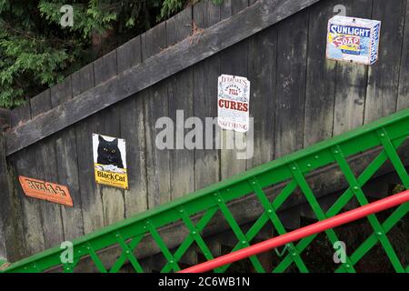 Période de publicité sur une clôture par la passerelle de la gare d'Alresford sur le chemin de fer à vapeur Mid-Hants (la ligne de Watercress), Hampshire, Angleterre, Royaume-Uni Banque D'Images