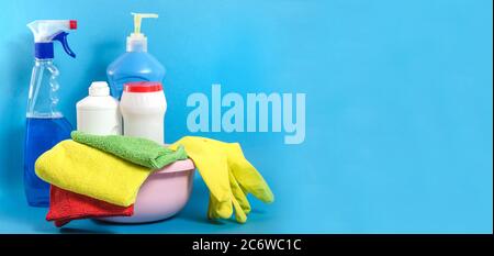 Bannière d'arrière-plan avec produits de nettoyage à la maison avec des serviettes colorées sur un fond bleu avec espace de copie. Nettoyage dans la maison Banque D'Images