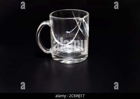 Coupelle cassée isolée sur un verre noir fissuré Banque D'Images