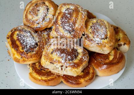 Viandes avec fromage cottage et raisins secs entassés sur une assiette blanche. Tartes saupoudrées de sucre en poudre Banque D'Images