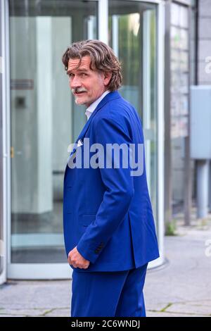 beau homme d'affaires en costume bleu dans ses années 50 debout à l'extérieur Banque D'Images