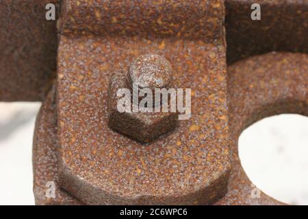 Bride texturée rouillée et boulon avec écrou sur plage de sable blanc Banque D'Images