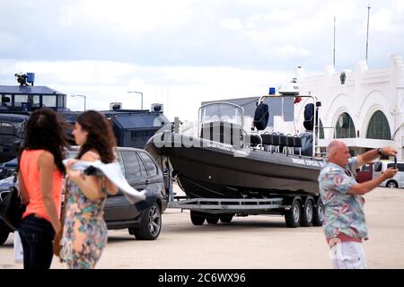Véhicules de police antiémeute et 2 femmes les regardant à Lisbonne, Portugal et bateau de police sur une remorque Banque D'Images