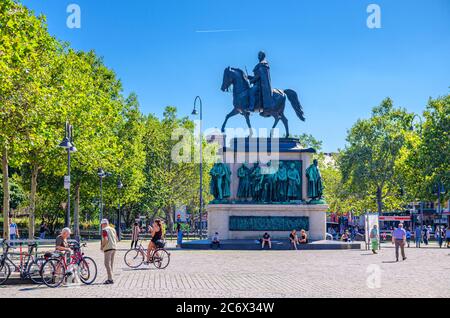 Cologne, Allemagne, 23 août 2019 : statue équestre du monument Friedrich Wilhelm III sur piédestal et les touristes se promenant sur la place pavée dans le centre historique de la ville, fond bleu ciel Banque D'Images