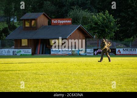 Oppenau, Allemagne. 12 juillet 2020. Un policier d'un SEK traverse un terrain de sport près de la communauté d'Oppenau. Un grand contingent de police a cherché un homme armé depuis le matin, qui aurait désarmé les officiers de contrôle au cours d'une inspection et s'est enfui. La police cherche maintenant l'homme dans les bois adjacents au site. Credit: Philipp von Ditfurth/dpa/Alay Live News Banque D'Images