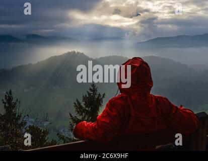 Touriste de repos méconnaissable regardant en automne jour brumeux sur le mont Watzmann fragments de silhouette dans contre lumière. Vue sur le ciel nuageux depuis le point de vue de Marienhohe Banque D'Images