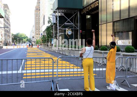 Mère et fille élèvent des poings devant la peinture murale Black Lives Matter peinte sur la 5e avenue directement devant la Trump Tower, Manhattan, New York City, USA le 12 juillet 2020 Banque D'Images