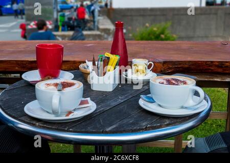 Tisch im Cafe mit Cappuccino Tassen und Gewürz Ständer Banque D'Images