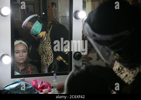 Les maquillages qui utilisent des équipements de protection individuelle font du maquillage pour la mariée et le marié avant la séance de photo avant mariage dans l'un des studios de photo Bekasi, dimanche (07/12/2020). Au moment d'une pandémie comme celle-ci est certainement un moment très difficile pour la profession d'un maquilleur. En plus des outils de maquillage qui touchent directement le visage du client, la propreté et la transmission ont également tendance à être vulnérables en raison de la distance et du contact physique qui est proche d'autres chiffres. (Photo de Kuncoro Widyo Rumpoko/Pacific Press/Sipa USA) Banque D'Images