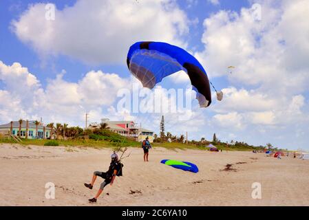 Melbourne Beach. Comté de Brevard. Floride. ÉTATS-UNIS. 12 juillet 2020. Parachutisme pour échapper à la Covid-19, prenant la distance sociale à la limite. Une centaine de canopées aux couleurs vives ont occupé le ciel au-dessus de cette ville côtière depuis trois jours, le groupe connu sous le nom de « Tribe of Voyager tikis Beach Boogie Skydiving ». Crédit photo : Julian Leek/Alay Live News Banque D'Images