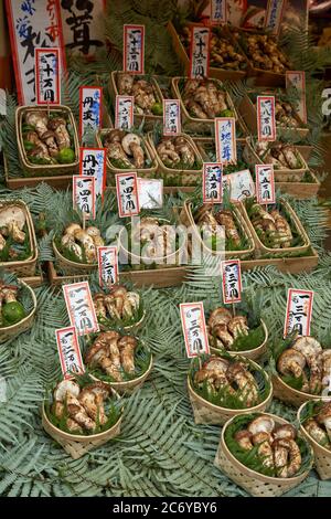 KYOTO, JAPON - 22 OCTOBRE 2007 : les paniers contenant des champignons domestiques (champignons de pin) se répartissent sur les feuilles de fougères en vente sur le marché de Kyoto Banque D'Images