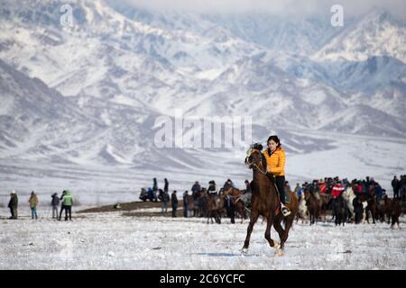 Une touriste étrangère fait un cheval local pendant un match de Kok Boru dans l'oblast de Chuy au Kirghizistan près de la capitale Bishkek. Banque D'Images