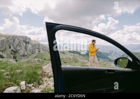 homme voyage en voiture et en utilisant un smartphone dans les montagnes Banque D'Images