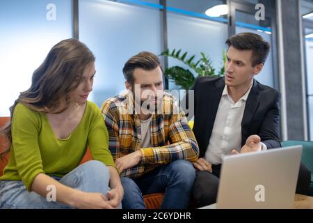 Jeune et confiant agent de vente consultant jeune couple Banque D'Images