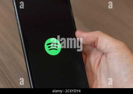 Personne utilisant un téléphone portable avec le logo Spotify Music streaming et Media Service à l'écran. Banque D'Images