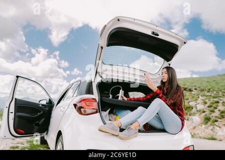 Femme utilisant le téléphone intelligent powerbank en charge et en voyage en voiture Banque D'Images