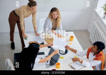 Des femmes diversifiées et prospères se sont réunies pour discuter de nouveaux projets d'affaires, d'idées et de partager leurs expériences. Jeunes femmes portant des vêtements décontractés Banque D'Images