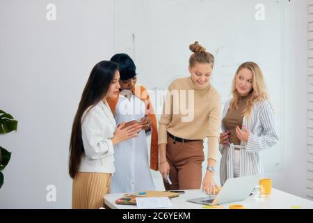 Utilisation d'un ordinateur portable moderne pendant le travail au bureau. Jeunes femmes leaders coworking utilisant l'ordinateur portable, travail d'équipe réussi de jeunes femmes. Concept de gens d'affaires, c Banque D'Images