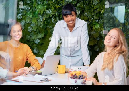 femme africaine à la bonne apparence qui a réussi à prononcer un discours à des femmes caucasiennes travaillant en équipe, auditeurs attentifs de la dirigeante des enseignants d'entraîneur africains Banque D'Images