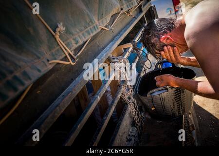 Juan Ahufinger, Shepherd, nettoie la tête en utilisant un seau dans le camp situé près de l'Arroyo de Las Tejas River près de Mota de Altarejos, Espagne Date : 23-06-2016. Photographe : Xabier Mikel Laburu. Juan, ho est passionnée par l'espagnol brave les bovins, a hérité d'un troupeau d'environ 800 moutons quand son père a pris sa retraite il y a plusieurs années. Juan est d'origine allemande, son nom vient de l'Ahufingher lorsqu'un de ses ancêtres sont venus travailler dans les mines de led sur le XIX siècle. La région entourant la Carolina est devenue le principal producteur de mineur conduit au 19ème siècle ce qui a amené beaucoup d'int Banque D'Images