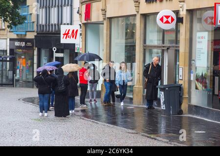 8 juillet 2020 les clients maintiennent leurs distances sociales en faisant la queue sous la pluie à l'extérieur de la succursale de la HSBC Bank à Fargate Sheffield, en Angleterre Banque D'Images
