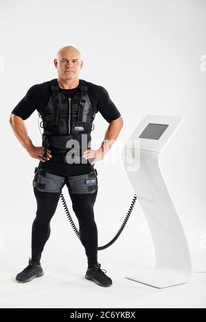Sportif fiable et bien construit en combinaison EMS posé à l'appareil photo. Photo pleine longueur. Temps libre, repos, santé et soins du corps Banque D'Images