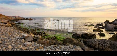 plage de la mer avec galets et rochers. beau paysage avec nuages au lever du soleil. vue panoramique sur une baie Banque D'Images