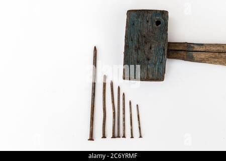 Vieux maillet en bois et clous rouillés sur fond blanc Banque D'Images