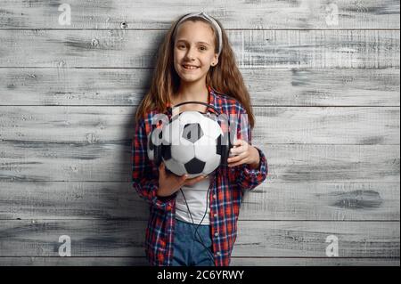 Une petite fille met un casque sur le ballon en studio Banque D'Images