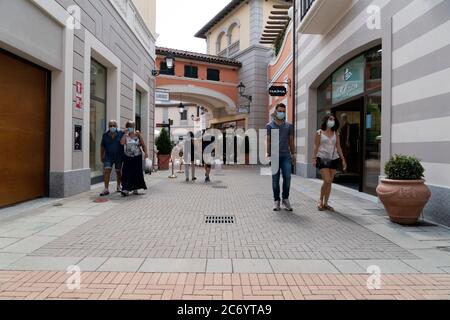 SERRAVALLE SCRIVIA, ITALIE - JUILLET 12 2020 - beaucoup de gens achetant des articles de mode au début de la boutique de créateurs Vente saison de port masque après covid Banque D'Images